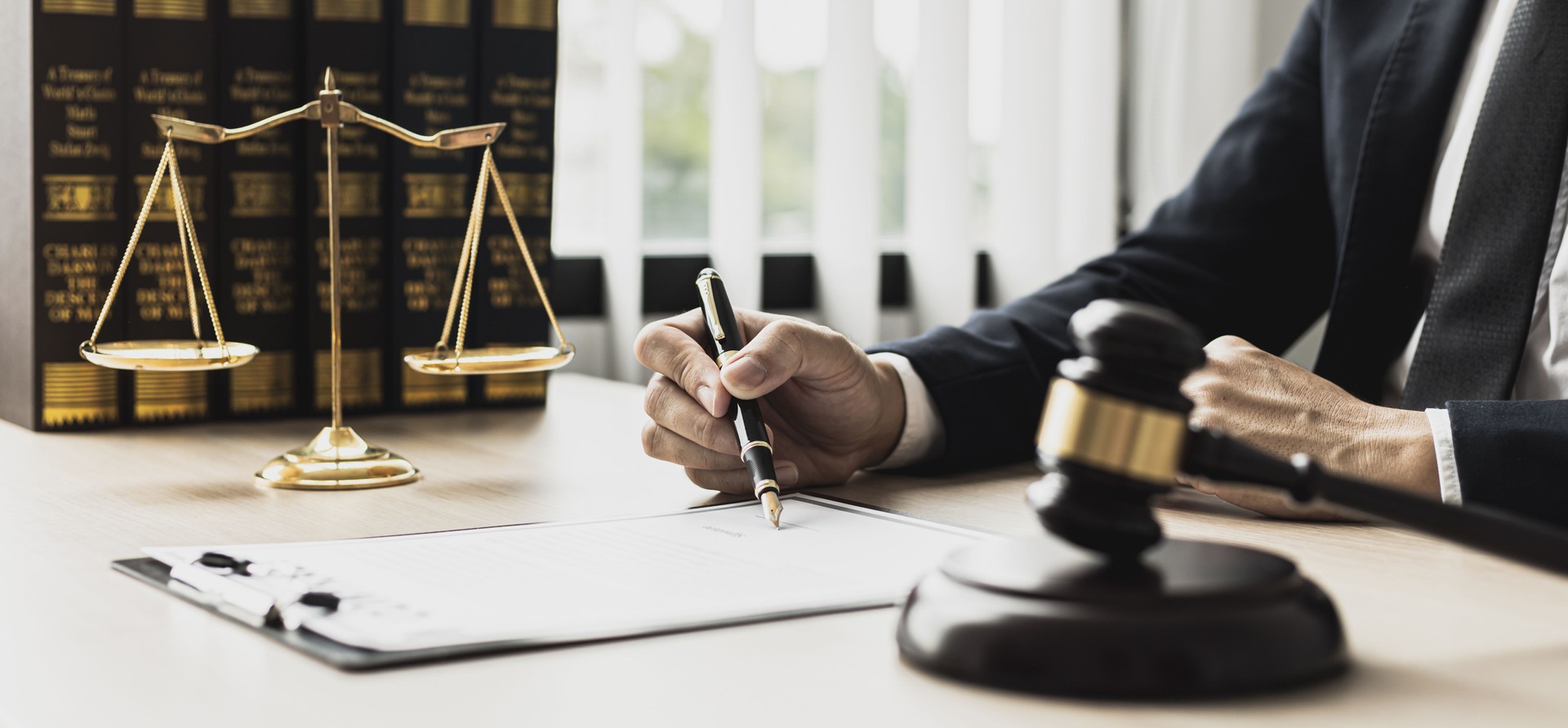 A male lawyer is signing a plea agreement with a client in a fraud case, in which the client has filed a lawsuit against an employee at a company that commits the fraud. Fraud litigation concept.