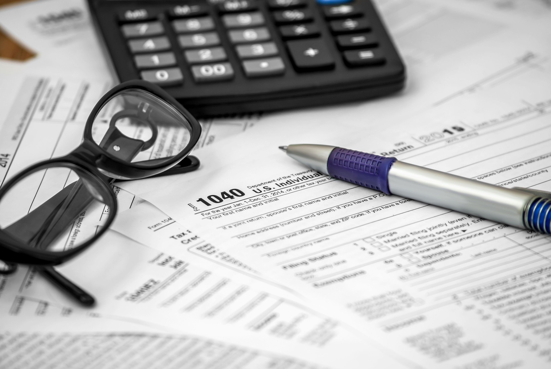 US tax form 1040 with pen, glasses and calculator